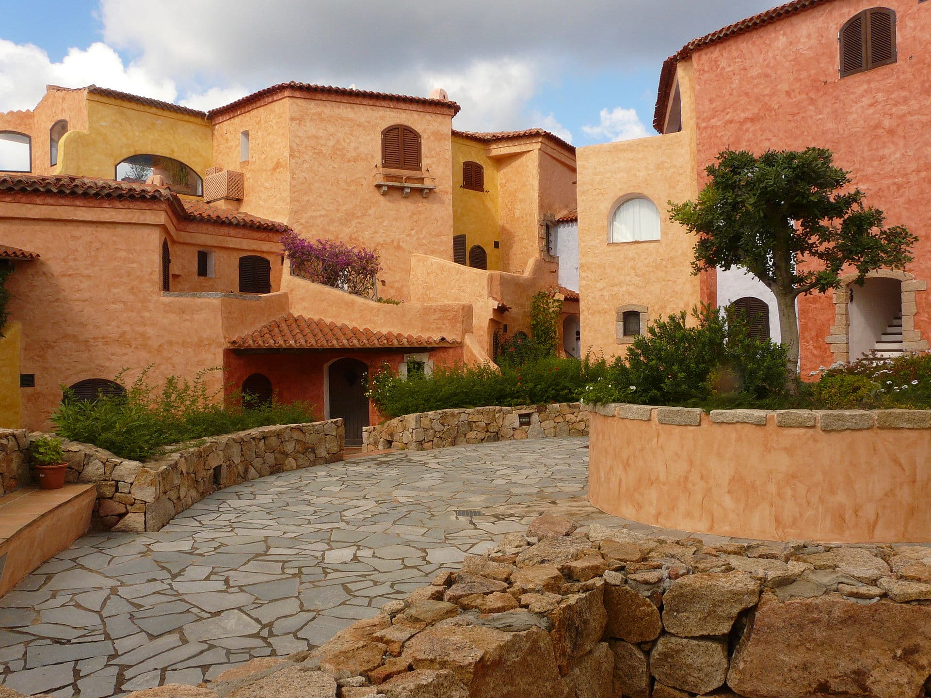 Ochre and limestone houses around a granite-paved court in Porto Rotondo.