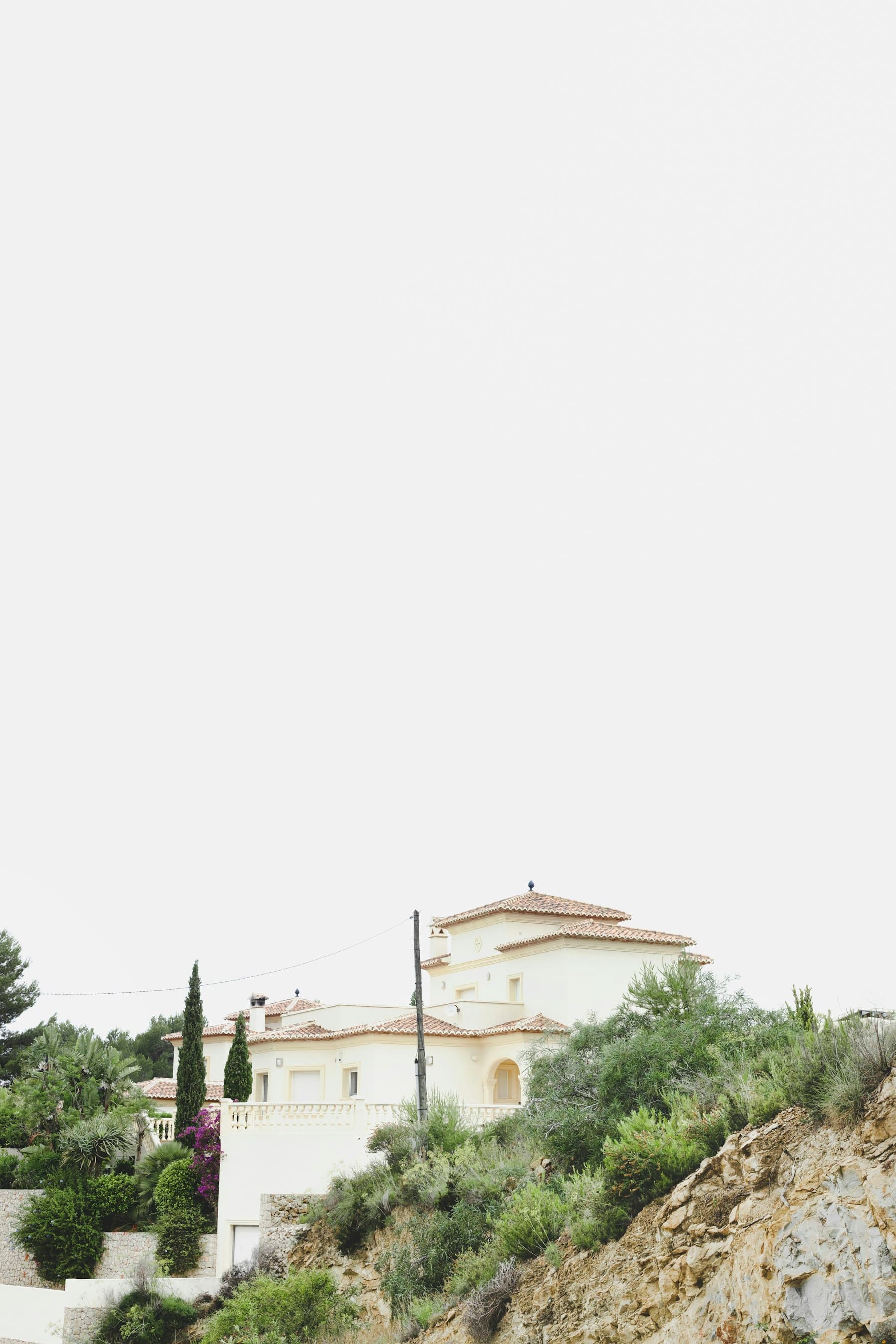 Pale hillside residence among Mediterranean planting.